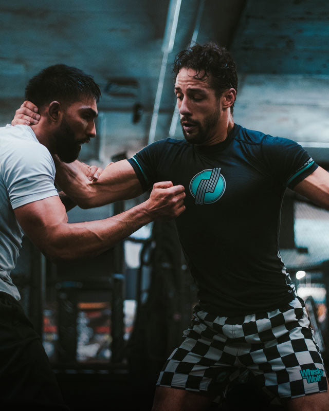 Two men in a gym setting, practicing bjj jiu jitsu grappling in whiskywolf apparel
